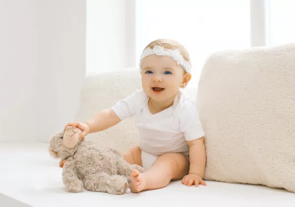 Cute Little Baby Playing With Toy At Home In White Room Near Window